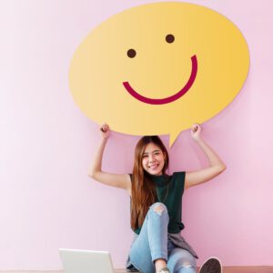 Frau hält einen smiley Plakat hoch