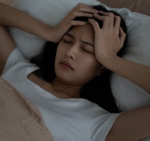 Frau liegt schlaflos im Bett